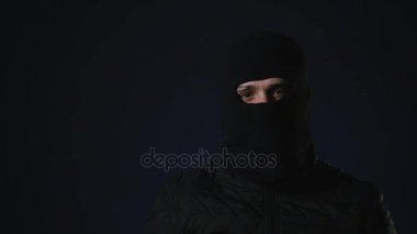 Maskeli bir adam elinde bir silah alır. Terörizm kavramı
