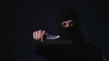 Karanlığın içinde bir bıçakla maskeli suçlu. Düşük anahtar spot ışığı ile filme