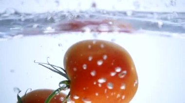 Taze büyük domates suya düşer ve baloncuklar yapar