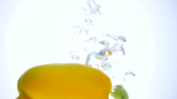 Peppers falling in water on white background — Stock Video