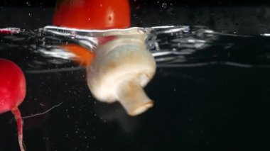 taze sebze su ile siyah arka plan üzerine düşen