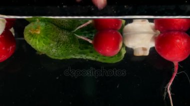 taze sebze su ile siyah arka plan üzerine düşen