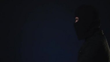 Maskeli bir adam elinde bir silah alır. Terörizm kavramı