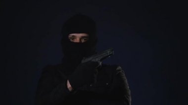 Maskeli bir adam elinde bir silah alır. Terörizm kavramı