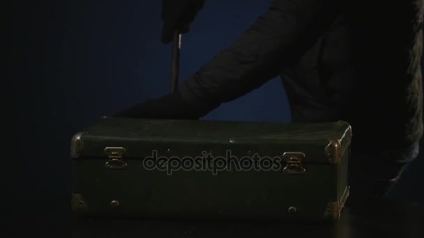 Maskierter Einbrecher öffnet Koffer mit Brecheisen — Stockvideo
