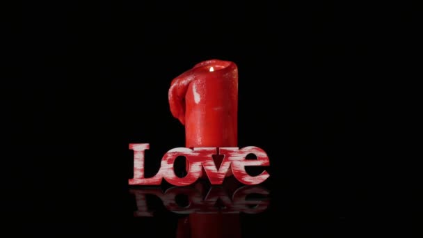 A single burning red candle rotate isolated in front of black background — Stock Video
