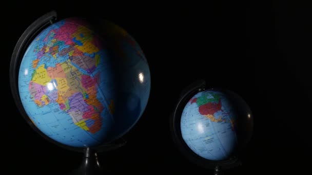 Lille og stor en globus roterende på sort baggrund – Stock-video