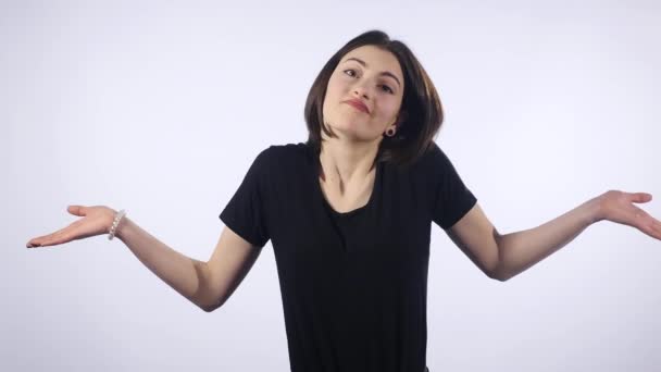 Jeune femme faisant ne sait pas signe sur fond blanc — Video