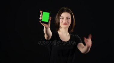 Eller genç kadın üzerinde yeşil arka plan izole ve ekranda gösteren boş smartphone ekran gösterilen