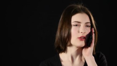 Çekici genç kadın bir cep telefonu ve çığlıklar söz. Siyah arka plan üzerine izole