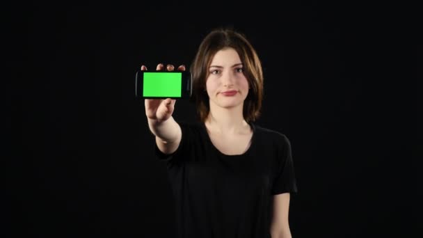 Young woman hands showing blank smartphone screen isolated on green background — Stock Video