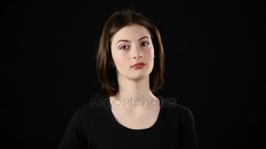 Yaşasın kadın mutlu veren başarı mutlu ve neşeli göz kırpıyor gülümseyen işareti ver. Studio siyah arka plan üzerine izole