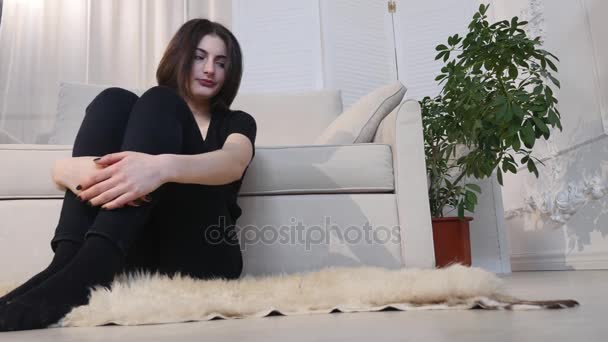 Giovane donna che guarda la TV seduta sul pavimento a casa — Video Stock