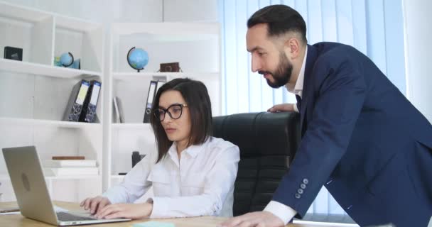 Homme d'affaires et femme utilisant un ordinateur portable au bureau — Video