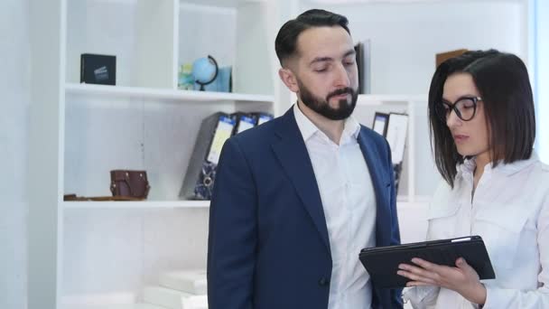 Empresários usando tablet computador com colega no fundo no escritório — Vídeo de Stock