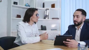 iş adamları oturup birlikte dijital tablet üzerinde verilere bakarak Toplantı