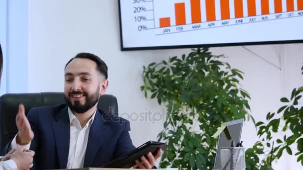 Uomo d'affari che spiega qualcosa a una donna con un tablet digitale in un ufficio — Video Stock