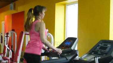 spor salonunda koşu bandı üzerinde çalışan kadın