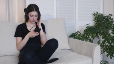 Genç kadın 4k evde koltukta oturan müzik dinle