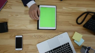 Dizüstü ve tablet ve akıllı telefon ile çalışan adam Üstten Görünüm tablo boş yeşil ekran dokunmatik