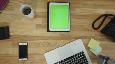 Dizüstü ve tablet ve akıllı telefon ile çalışan adam Üstten Görünüm tablo boş yeşil ekran dokunmatik