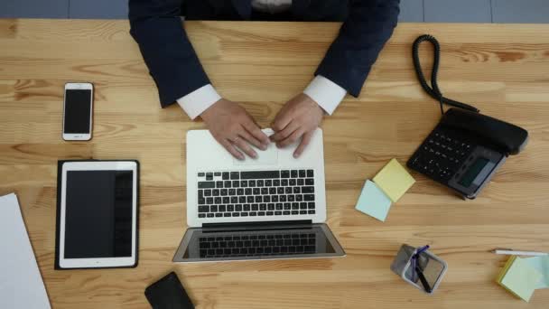 Ansicht von oben: Mann arbeitet auf Laptop und Tablet und Smartphone mit Touchscreen, grüner Bildschirm auf Tisch — Stockvideo