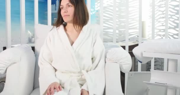 Beautiful young woman in spa salon with remote control — Stock Video