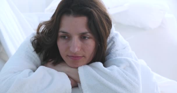 Hübsche junge Frau im Bademantel blickt in die Kamera — Stockvideo