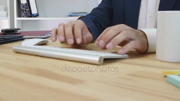 Um empresário satisfeito sentado em seu escritório trabalhando em seu computador — Vídeo de Stock