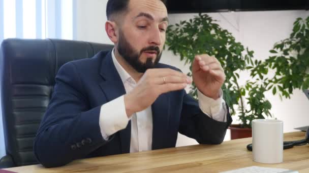 Молодой бизнесмен страдает головной болью во время работы в офисе — стоковое видео