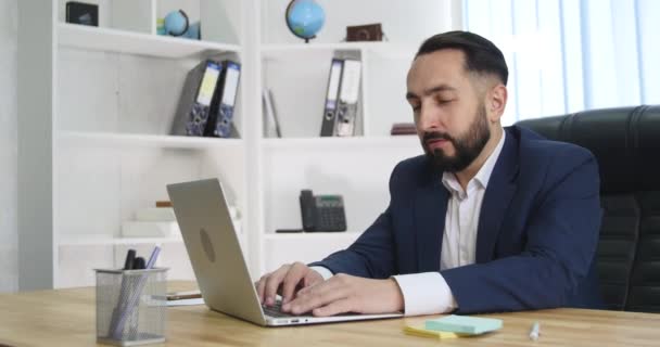 Ofiste dizüstü bilgisayar üzerinde çalışan iş adamı — Stok video