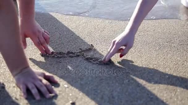 Junges schönes Paar am Strand macht Herz — Stockvideo