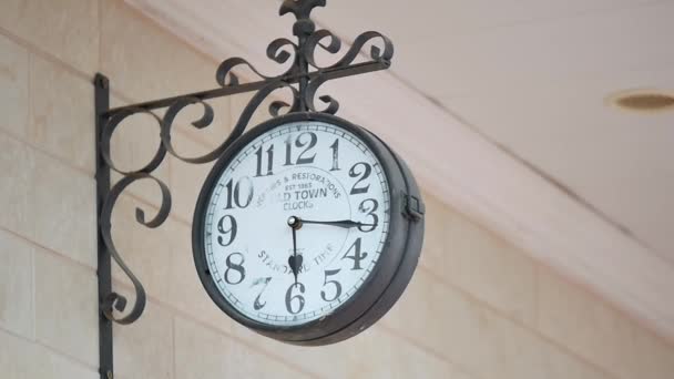 Reloj de pared vintage en un soporte de metal forjado en la pared — Vídeo de stock