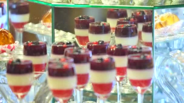 Deliciosos dulces en buffet de caramelos. Muchos postres coloridos en la mesa — Vídeo de stock