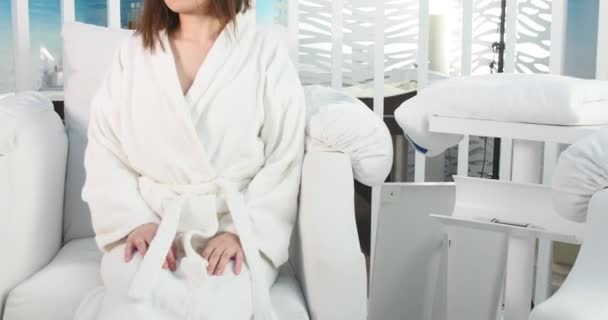 Bella giovane donna nel salone spa con telecomando — Video Stock