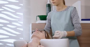 Kuaför Güzellik salonunda bir saç maskesi petrol çekici kız için yapar. Kuaför bir istemci saç güzellik salonunda yıkar.