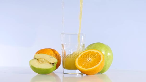 El jugo de manzana y la naranja se vierten en un vaso. Bebida de manzana. Manzana fresca — Vídeos de Stock