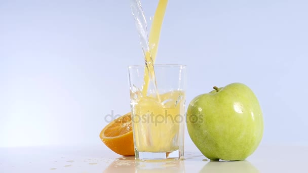 Яблочный сок и апельсин наливают в стакан. Яблочный напиток Яблоко свежее — стоковое видео