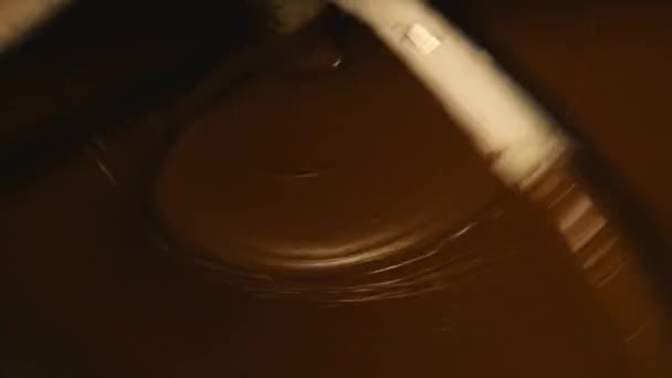Uma máquina mistura chocolate escuro em uma fábrica — Vídeo de Stock