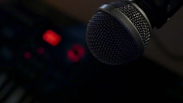 Microfone em um estande localizado em uma cabine de gravação de estúdio de música sob luz de tecla baixa — Fotografia de Stock