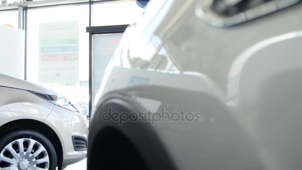 Young family comes into Car dealership to choose the car to buy it — Stock Video