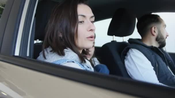 Besuch beim Autohaus. schöne Familie spricht und lächelt, während sie in ihrem neuen Auto sitzt — Stockvideo