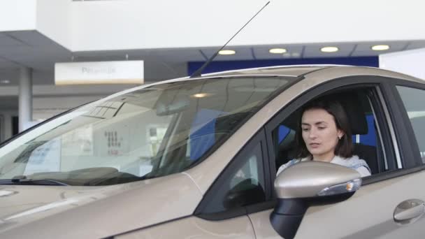 Conducteur femme heureuse montrant les clés de la voiture et s'appuyant sur la porte de la voiture — Video