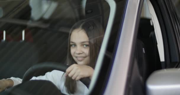 Happy baby flicka visar nyckeln i sin nya bil. Bilbranschen, bil försäljning, teknik och människor koncept - glad hane med bilhandlare i auto visa eller salong. Ung man med en försäljare i en motor show — Stockvideo