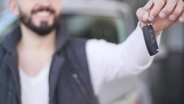 Glücklicher junger Mann mit Schlüsseln für ein neues Auto. Selektiver Fokus — Stockvideo