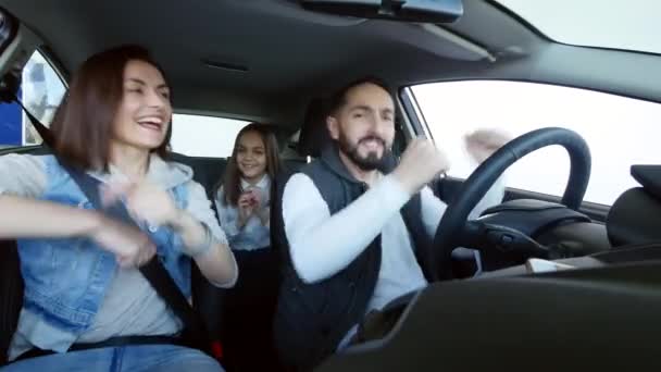 Feliz familia sonriente bailando en un coche familiar — Vídeos de Stock