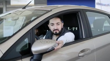 Araba satıcısı yeni arabanın anahtarlarını veriyor.