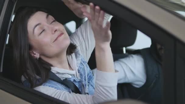 Visitando concesionario de coches. Hermosa familia está bailando y sonriendo mientras se sienta en su nuevo coche — Vídeos de Stock