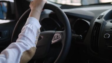 uzağa bakarak ve bir Otomobil Fuarı yeni arabada otururken gülümseyen güzel bebek kız kamera arkası