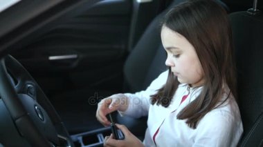 uzağa bakarak ve bir Otomobil Fuarı yeni arabada otururken gülümseyen güzel kız bebek